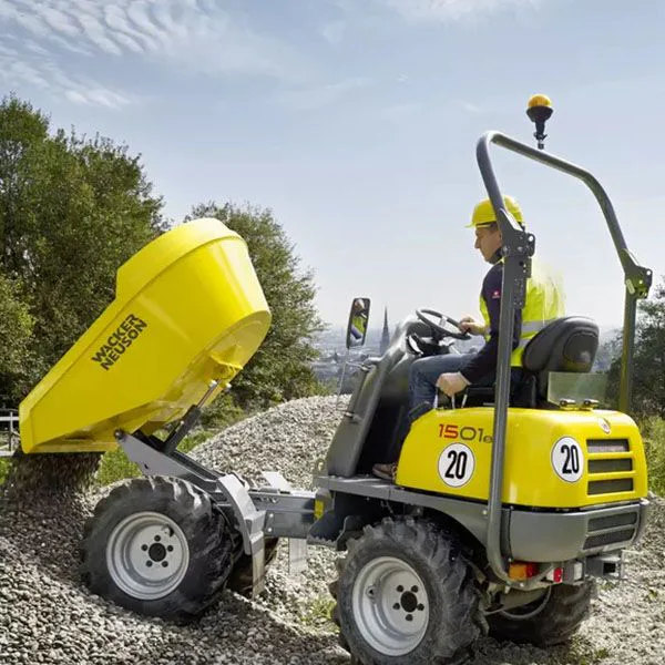 Operador utilizando el dumper Wacker Neuson 1501 para transportar áridos en terreno irregular, destacando la estabilidad y seguridad de la máquina