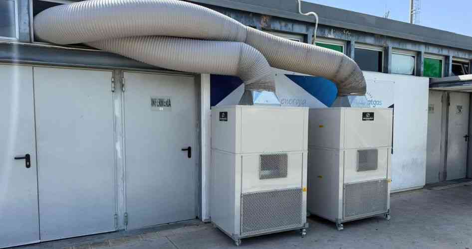 Two large industrial air‑handling units with flexible ductwork extending across a building exterior.